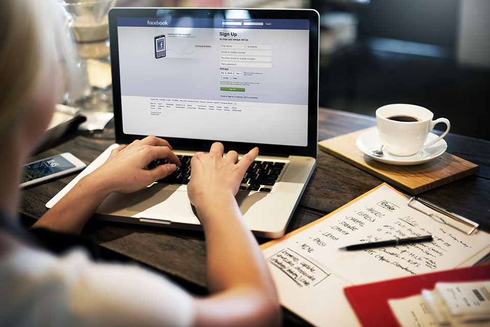 Young-Woman-Using-Facebook-Application-on-her-Laptop